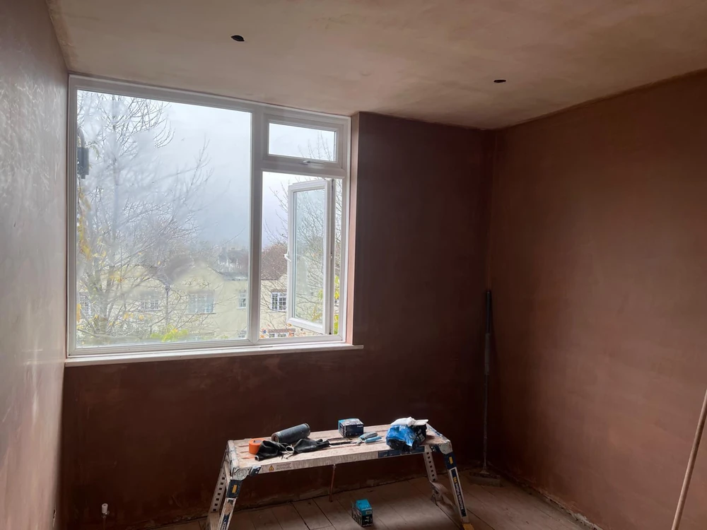 Room with fresh finishing plaster drying, downlight cutouts prepared
