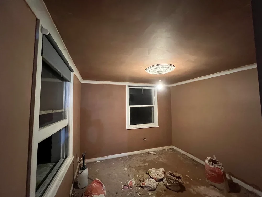 Period room with walls and ceiling freshly plastered around a retained ceiling rose