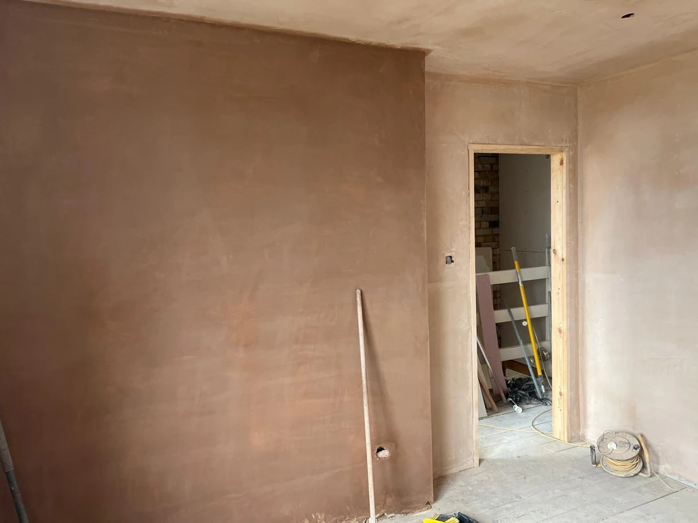 Walls and ceiling coated in freshly applied wet plaster